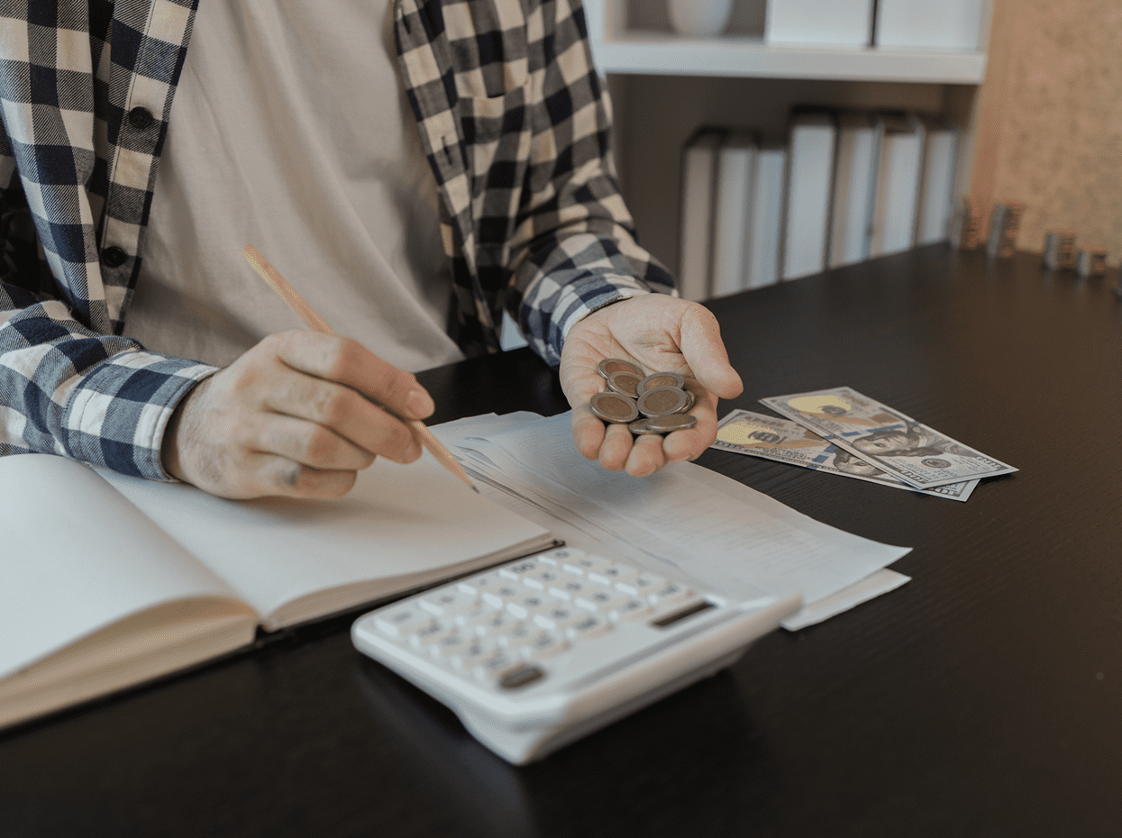 Counting money at a desk with notebook.