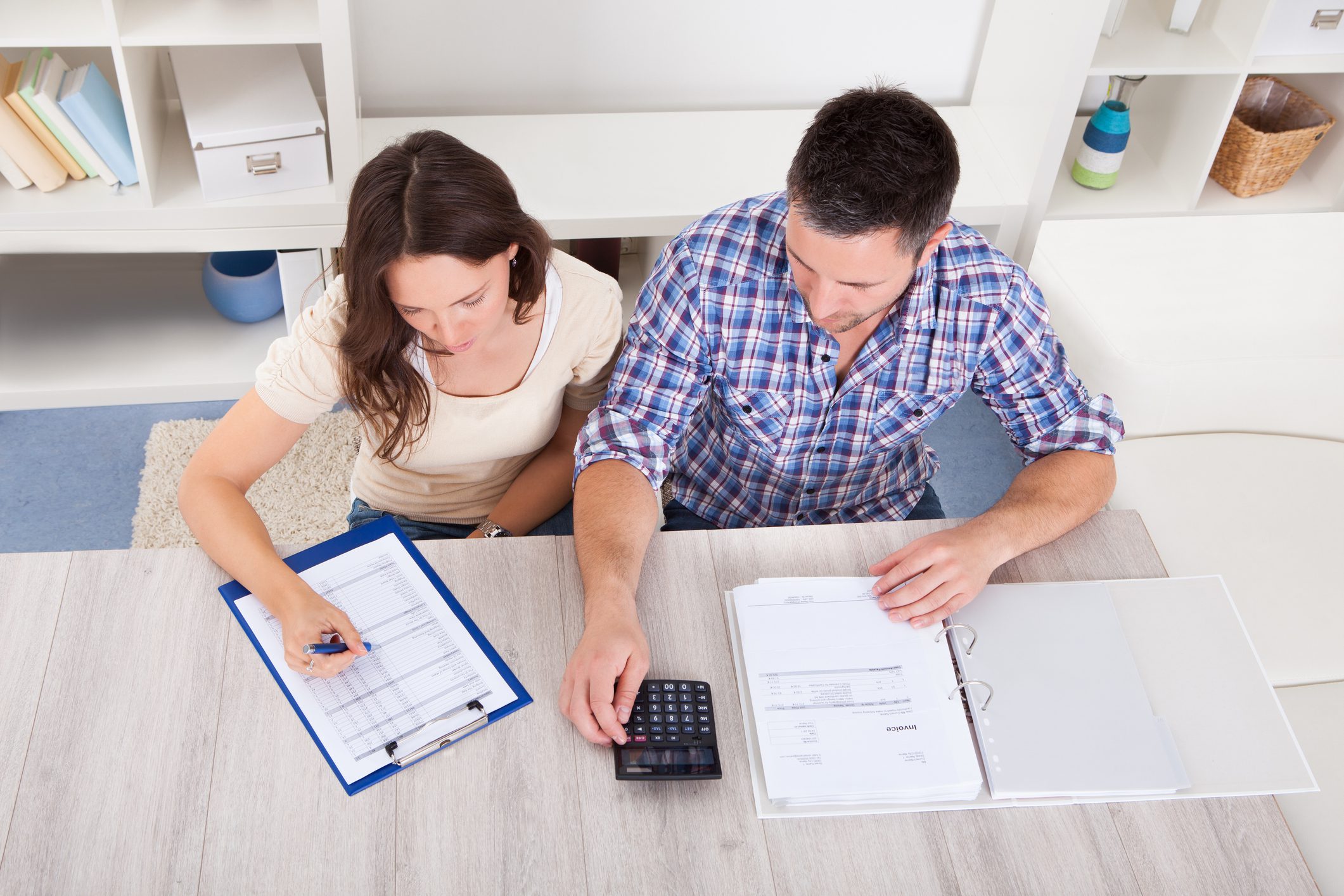 Portrait Of A Young Couple Calculating Finance At Desk